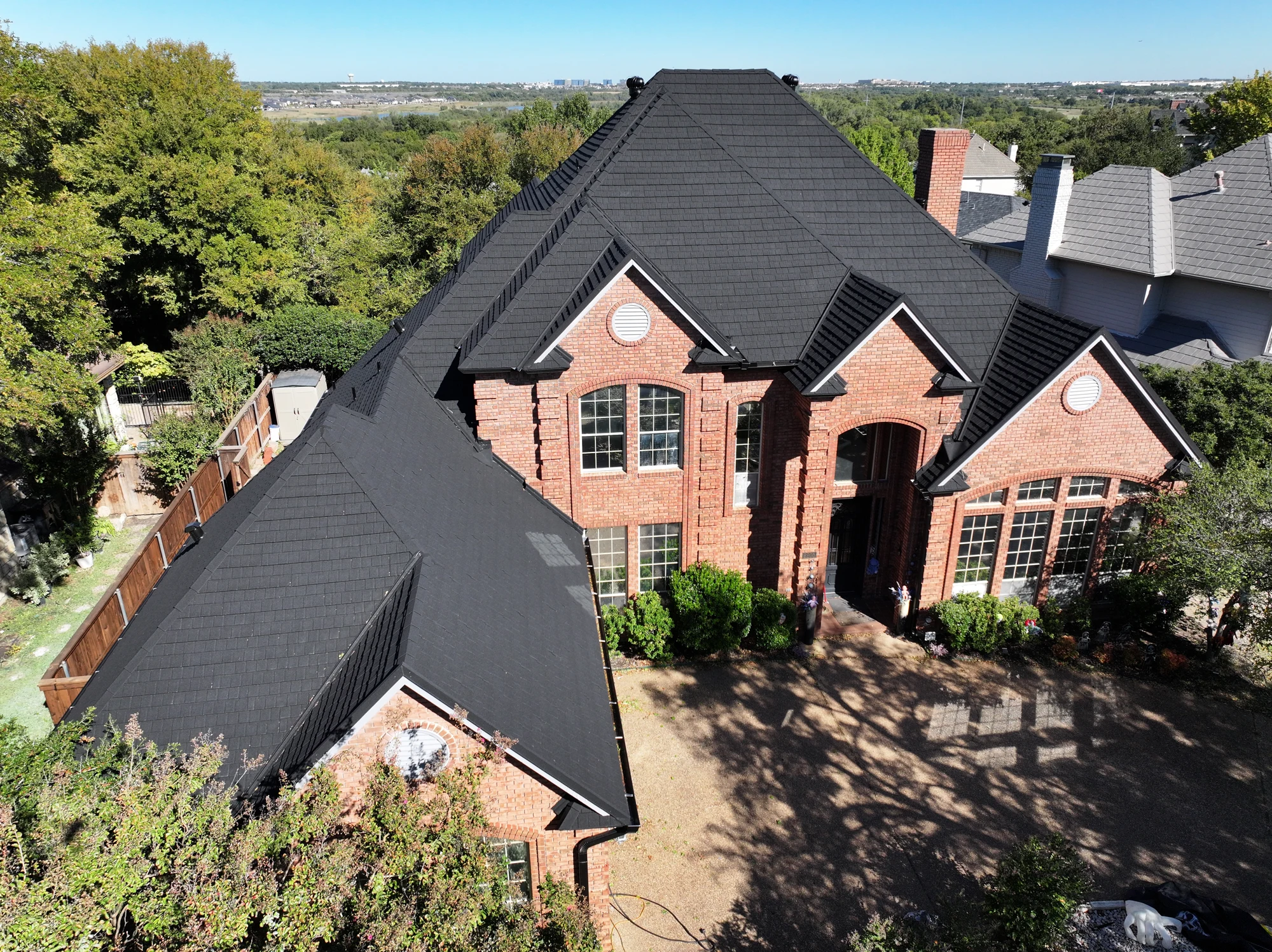 Black Stormetal shingle roof on a completed brick home